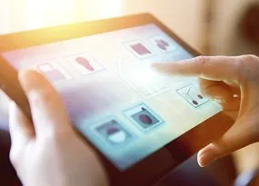 Person steuert die Beleuchtung einer Wohnanlage &uuml;ber ein Tablet. 